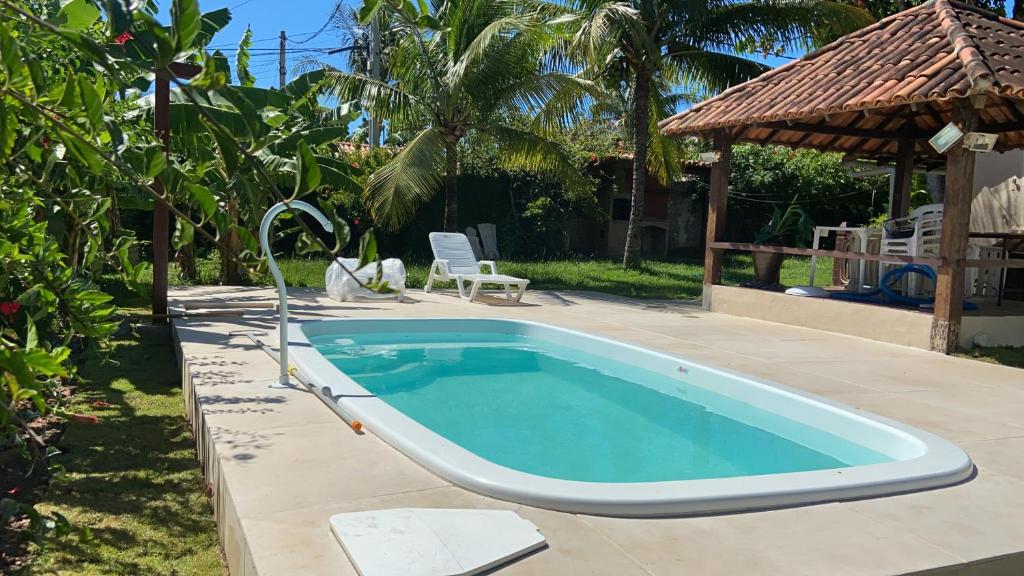 a swimming pool in a yard next to a house at Casa de 5 suítes e piscina em Geribá in Búzios