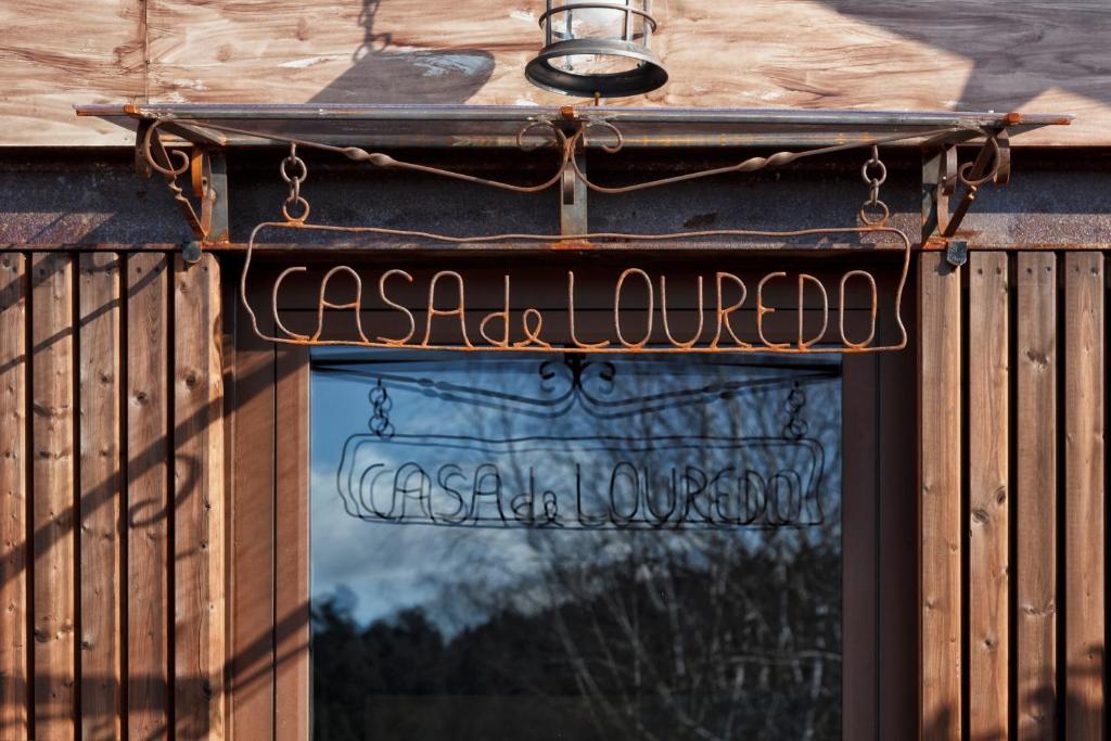 un panneau indiquant un restaurant sur une clôture en bois dans l'établissement Casa de Louredo, à Paredes