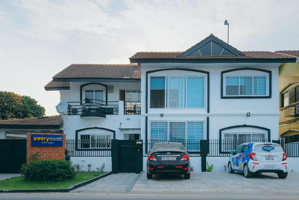 阿克拉The Avery Suites, East Legon的两辆汽车停在房子前面