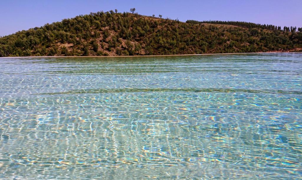 una gran masa de agua con una isla en el fondo en Monte Corgo da Vaca, en Sabóia
