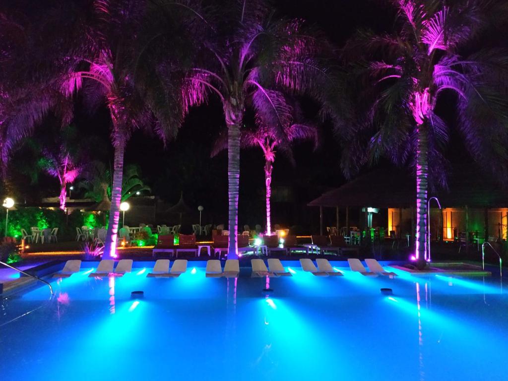 uma piscina com cadeiras e palmeiras à noite em Hotel Termal Emperatriz Termas de Río Hondo em Termas de Rio Hondo