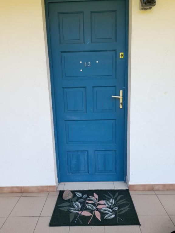 uma porta azul com um tapete em frente em STUDIO LE DIAMANT LES PIEDS DANS L'EAU l em Le Diamant