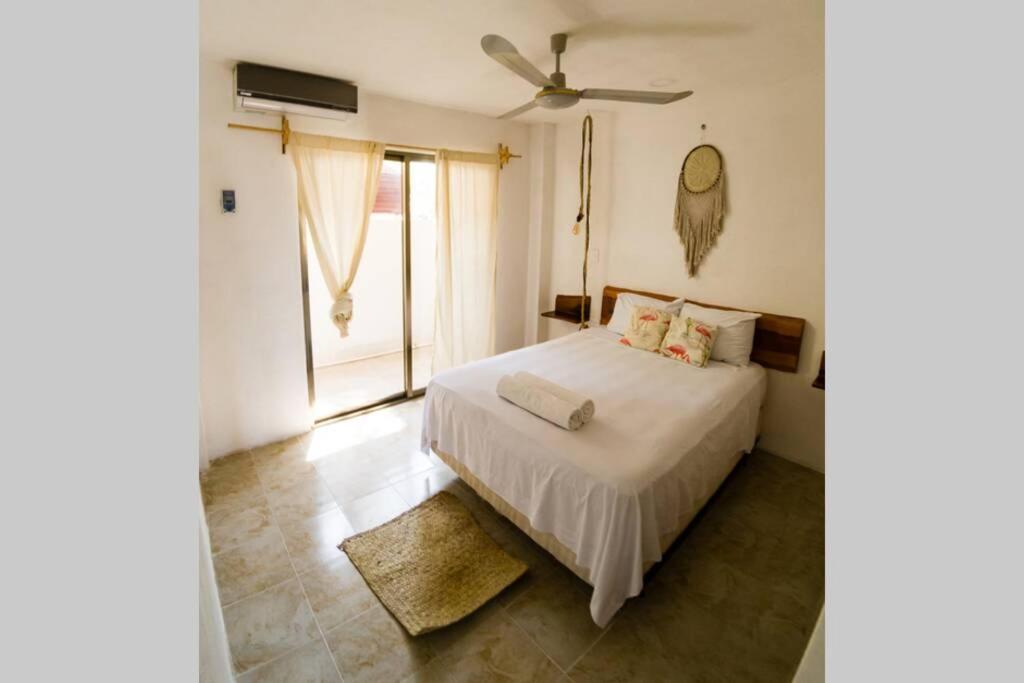 1 dormitorio con cama blanca y ventana en Costa Esmeralda, en El Cuyo
