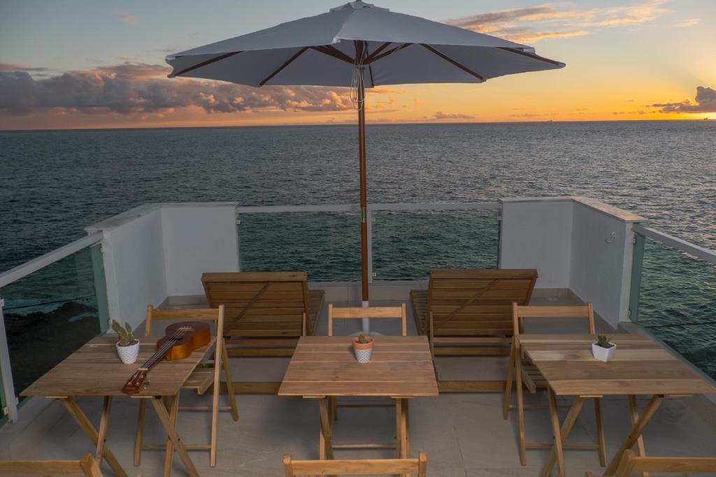 uma mesa com cadeiras e um guarda-sol num navio de cruzeiro em La Plage Salvador - Boutique Hostel em Salvador