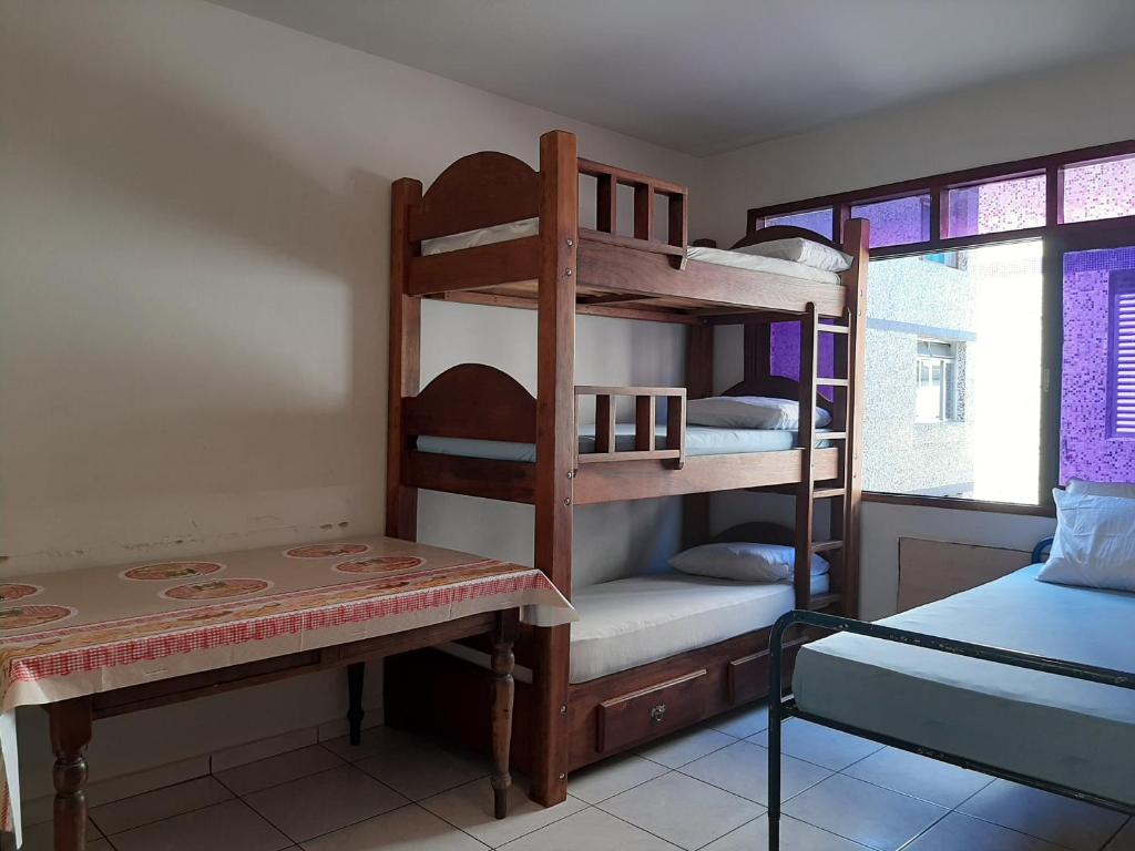 um quarto com 2 beliches e uma mesa em Apartamento mobiliado no Canto do Forte - Praia Grande - SP Férias, temporada, feriados em São Paulo