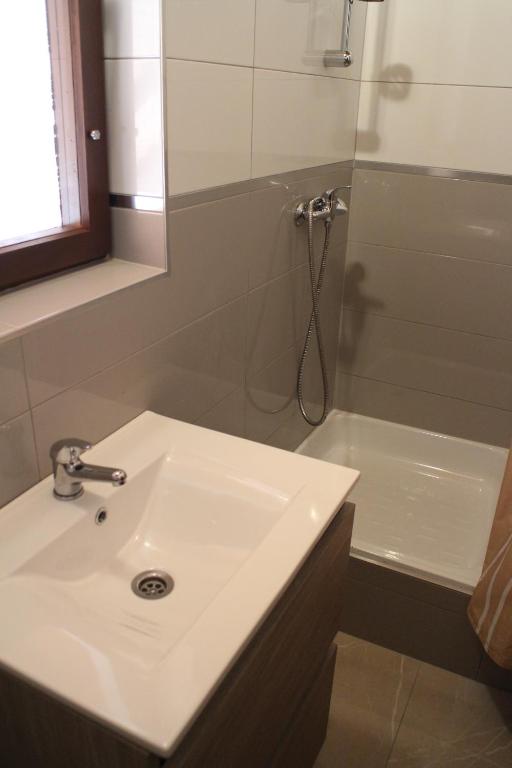 a bathroom with a sink and a shower with a mirror at Balassa Weekendhouse in Siófok