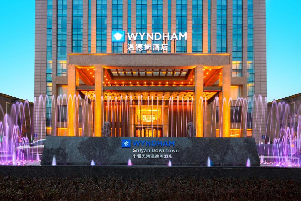 a large building with a fountain in front of it at Wyndham Shiyan Downtown in Shiyan