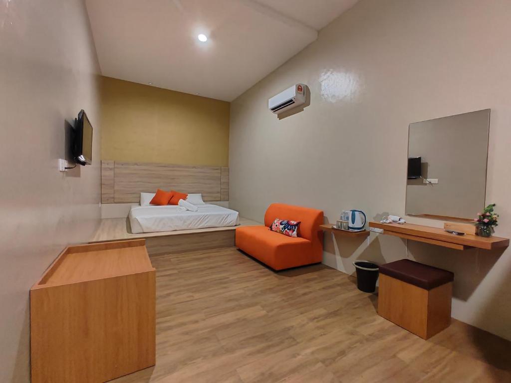 Habitación con cama, silla y espejo. en DURIAN HILL VILLA, en Gua Musang