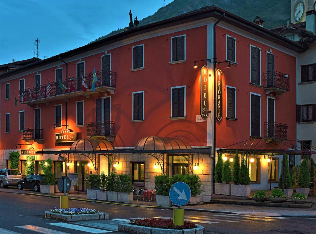 un bâtiment rouge avec un panneau devant lui dans l'établissement Bes Hotel Papa San Pellegrino Terme, à San Pellegrino Terme