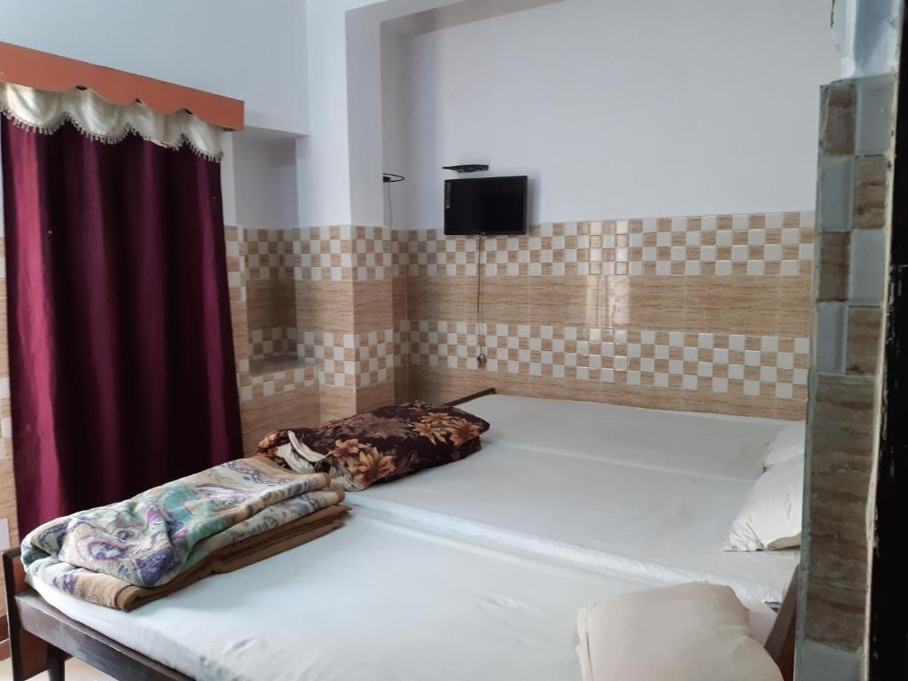 巴特那的住宿－Hotel Yuvraj，一张大床,位于一个红色窗帘的房间