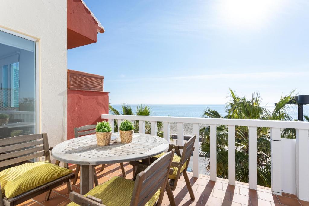 einen Balkon mit einem Tisch, Stühlen und Meerblick in der Unterkunft Higuerón Rental Marítimo Romar D in Fuengirola