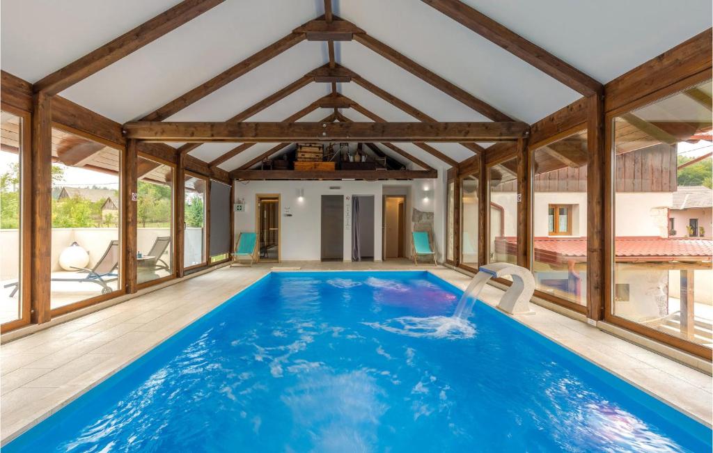 a swimming pool in a house with wooden beams at Stunning Home In Gospic With Sauna, Wifi And Indoor Swimming Pool in Gospić