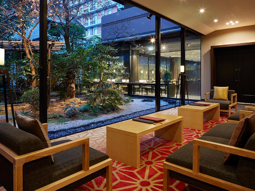a lobby with chairs and tables in a building at Mitsui Garden Hotel Kyoto Sanjo in Kyoto