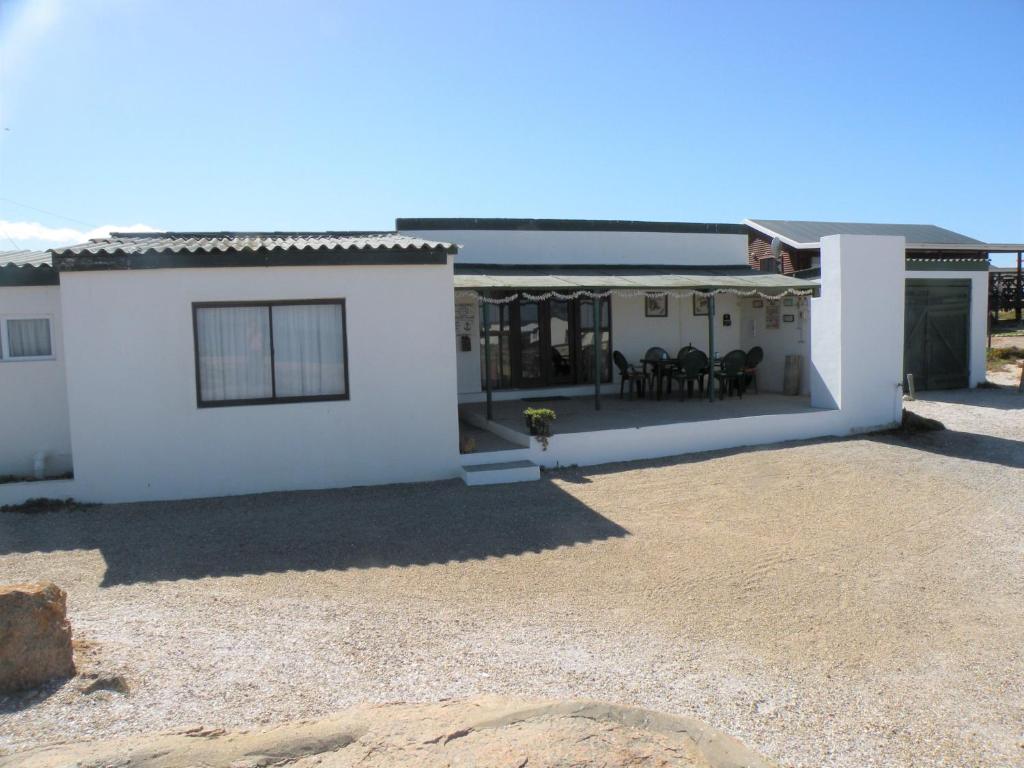 a white house with a patio in front of it at Honne-Hemel Oubaas in Hondeklipbaai