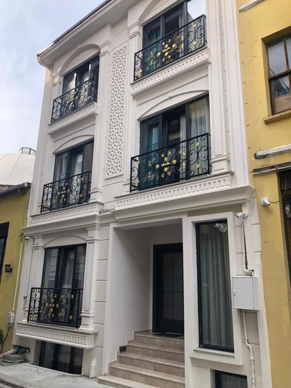 a white building with balconies and stairs on it at Pege Hotel in Istanbul