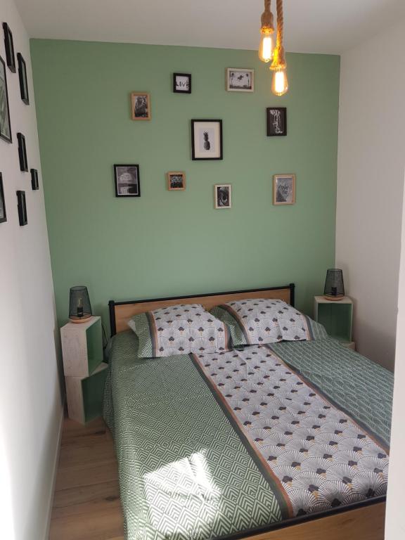 1 dormitorio con 1 cama y cuadros en la pared en Normandie Sword Beach, en Hermanville-sur-Mer