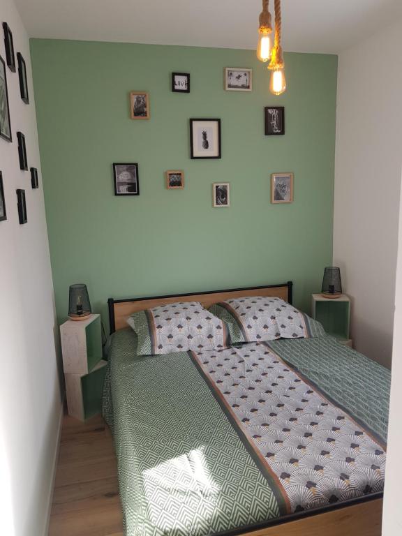 a bedroom with a bed and pictures on the wall at Normandie Sword Beach in Hermanville-sur-Mer