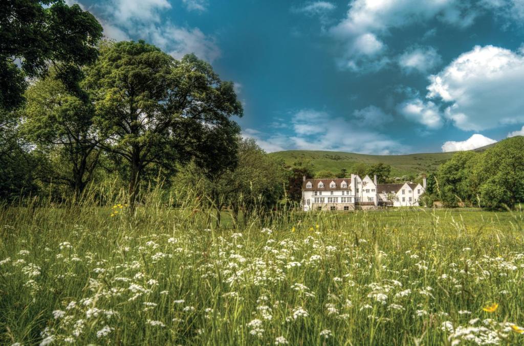 a field of flowers with a house in the background at Losehill House Hotel & Spa in Hope