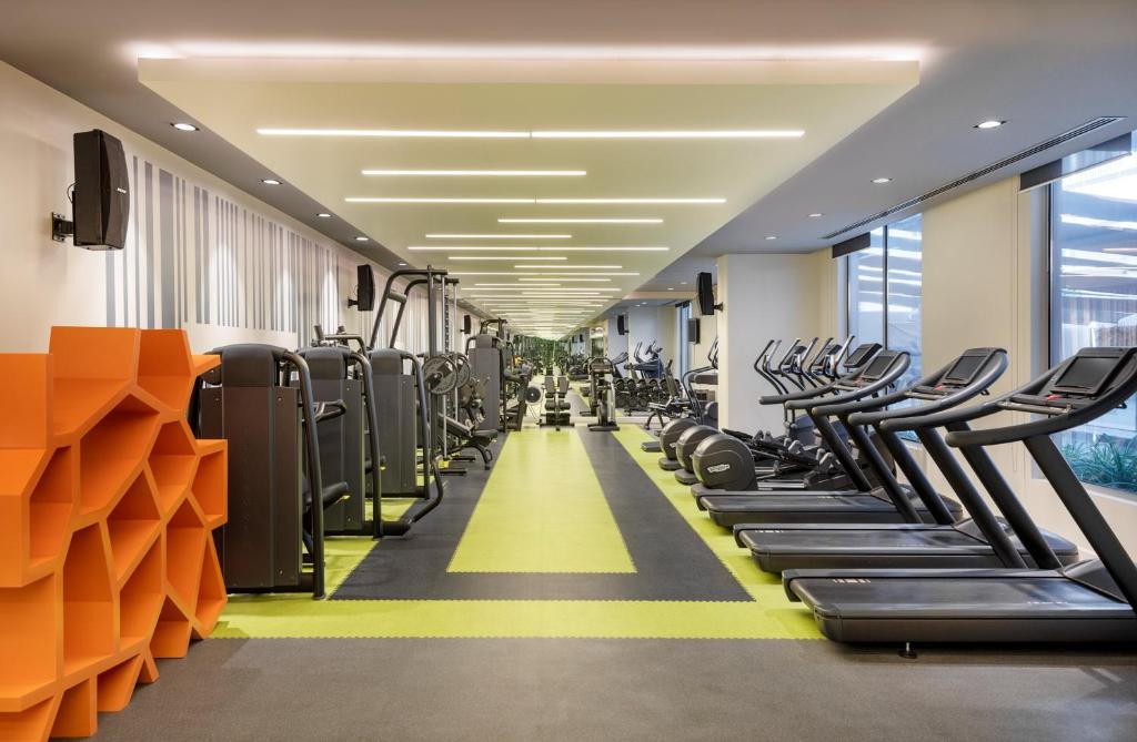 a gym with rows of treadmills and machines at Holiday Inn - Doha - The Business Park, an IHG Hotel in Doha