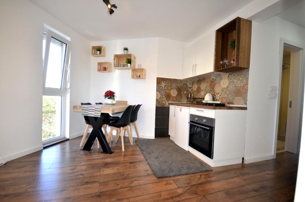 C l e a n&C o z y Apartmani Divcibare في ديفشيبار: مطبخ مع طاولة وغرفة طعام
