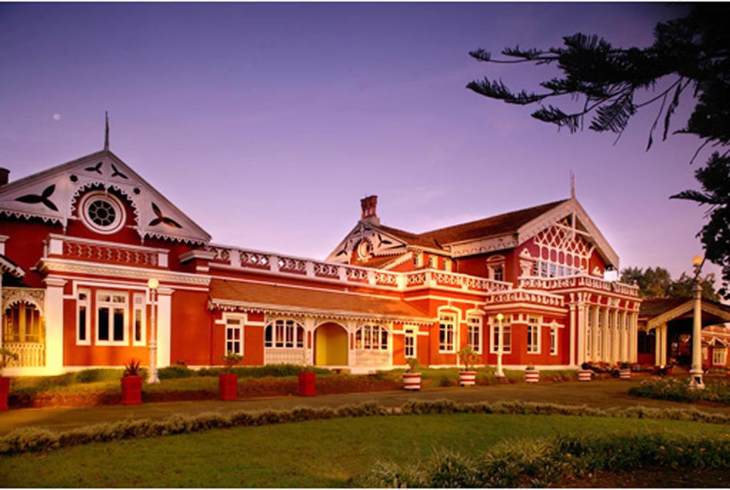een groot rood gebouw met veel ramen bij WelcomHeritage Fernhills Royal Palace in Ooty