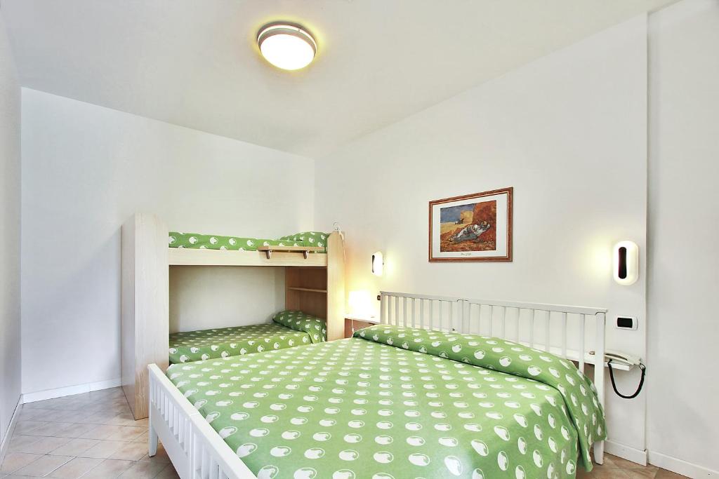 ein Schlafzimmer mit einem Bett und einem Etagenbett in der Unterkunft Aparthotel Ponza in Lignano Sabbiadoro