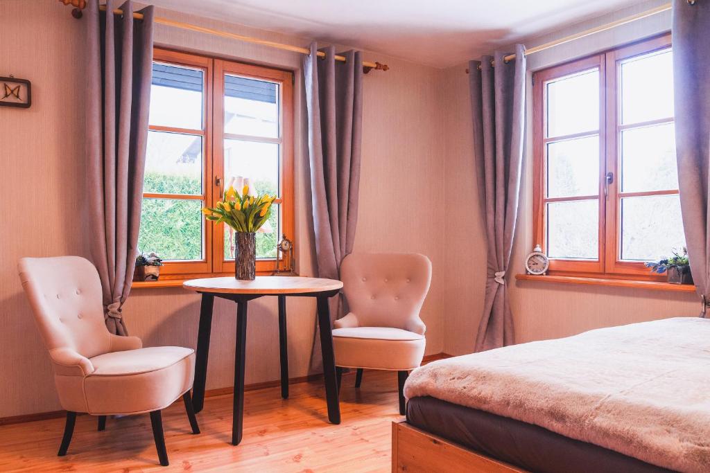 sypialnia ze stołem, 2 krzesłami i łóżkiem w obiekcie Sielankowy domek w górach w Bielsku Białej
