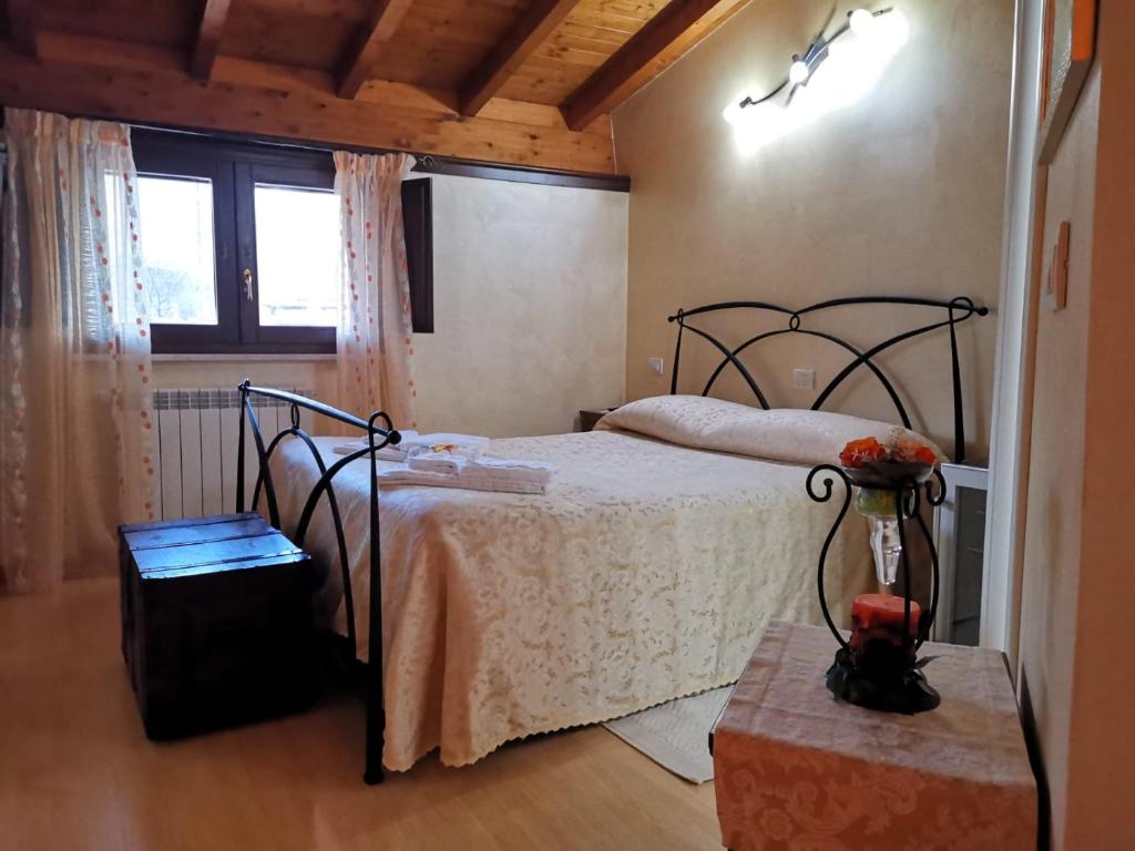 1 dormitorio con cama, ventana y mesa en B&B La Coccinella, en Amaseno