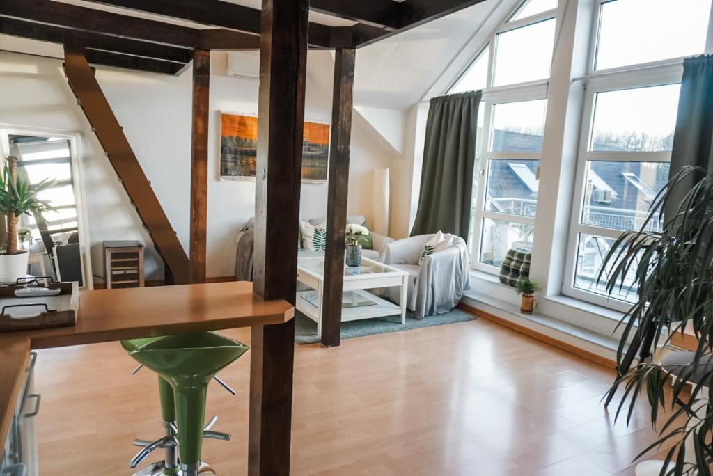 a living room with large windows and a table at Surfer Loft with AC and sun terrace in Bonn