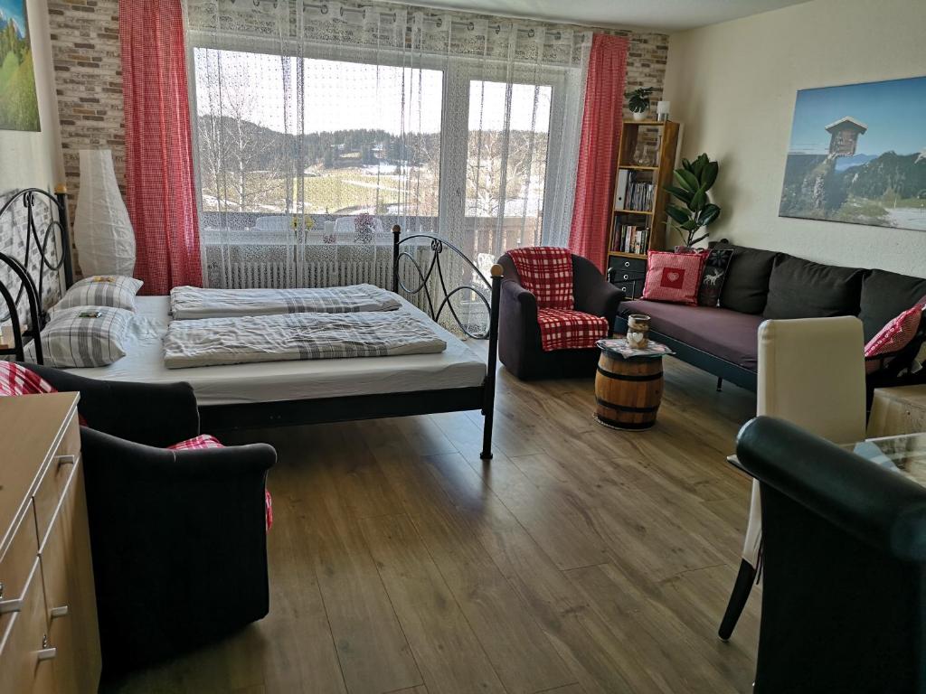 a living room with a bed and a couch at Ferienwohnung Ausblick in Missen-Wilhams