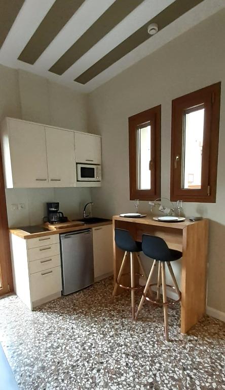 a kitchen with a counter and two chairs in it at Andros 4 All Seasons Villas & Suites in Andros