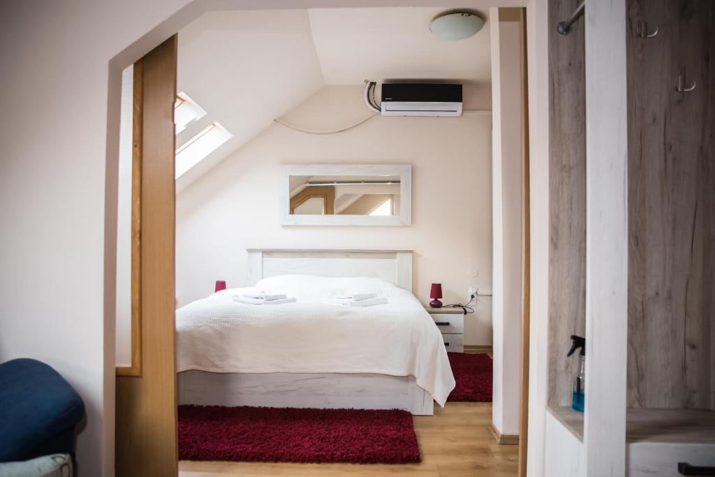 a bedroom with a white bed in a attic at Apartament Delta in Bistriţa