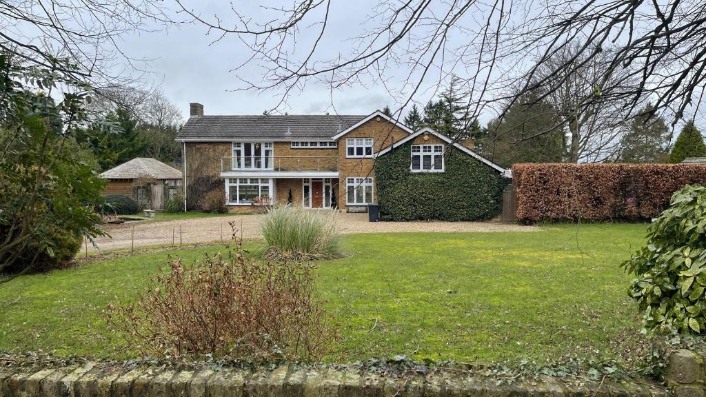 una casa grande con un patio con césped en Stunning Oxfordshire 5 Bedroom House in 2 acres, en Aston Rowant