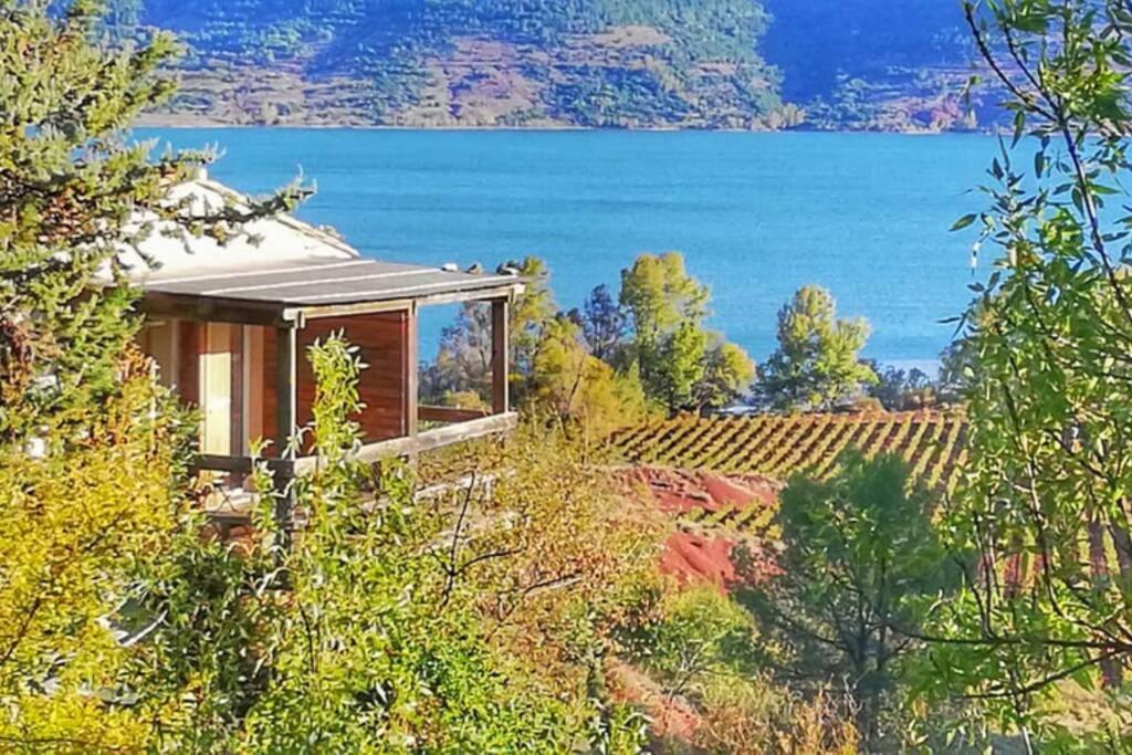 a house on a hill with a view of the water at Studio 22 m2, terrasse vue lac, dans propriété face au Lac du Salagou in Liausson