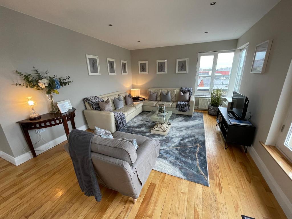 uma sala de estar com um sofá e uma televisão em Penthouse Apartment em Kilkenny