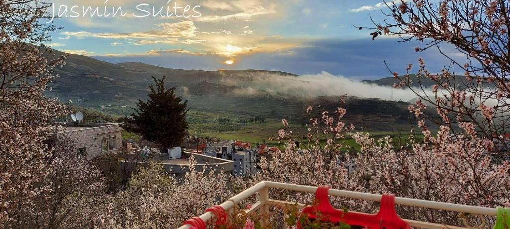 a view of a valley with the sun setting over the hills at Jasmin Suites in Majdal Shams
