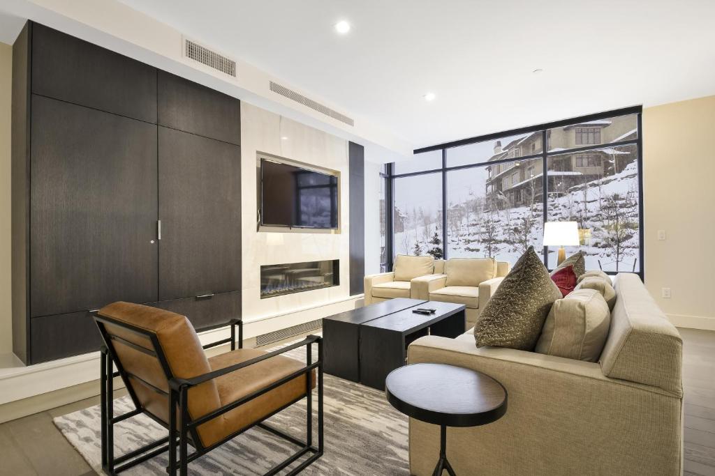 a living room with a couch and chairs and a tv at 3BR Luxury Residence in Canyons Village- Ski in ski out! condo in Park City