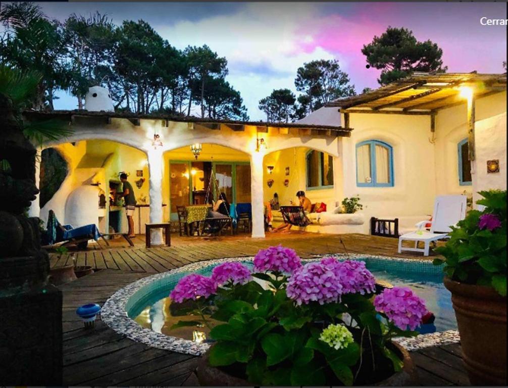 a house with a swimming pool and purple flowers at El Delfin in Punta del Este