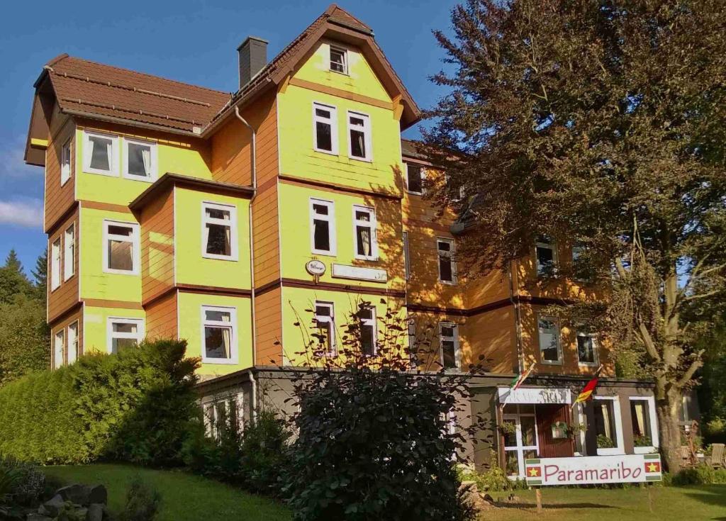 een groot geel huis met een bruin dak bij Landhaus Irmgard in Braunlage