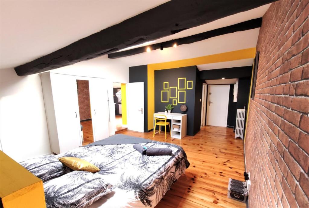 une chambre avec un lit et un mur de briques dans l'établissement LA TERRASSE DE JEANNE - Vue Magnifique - Netflix, à Toulouse