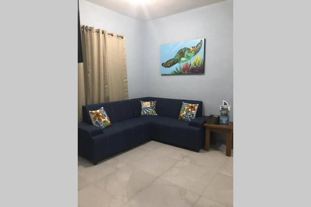 sala de estar con sofá azul y mesa en Brand new apartment, charming and family-friendly, en Playa del Carmen