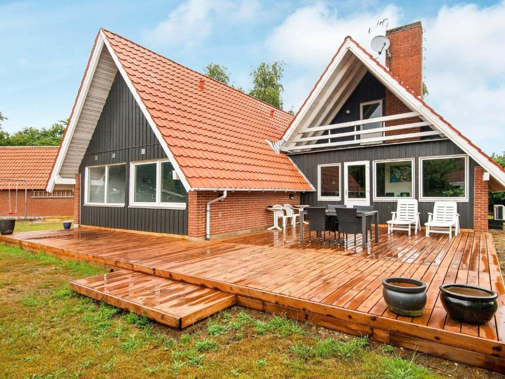 a house with a wooden deck in front of it at Holiday home Glesborg LXV in Glesborg