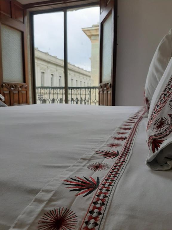 a bed in a room with a view of a building at Casa de Siete Balcones Hotel Boutique in Oaxaca City