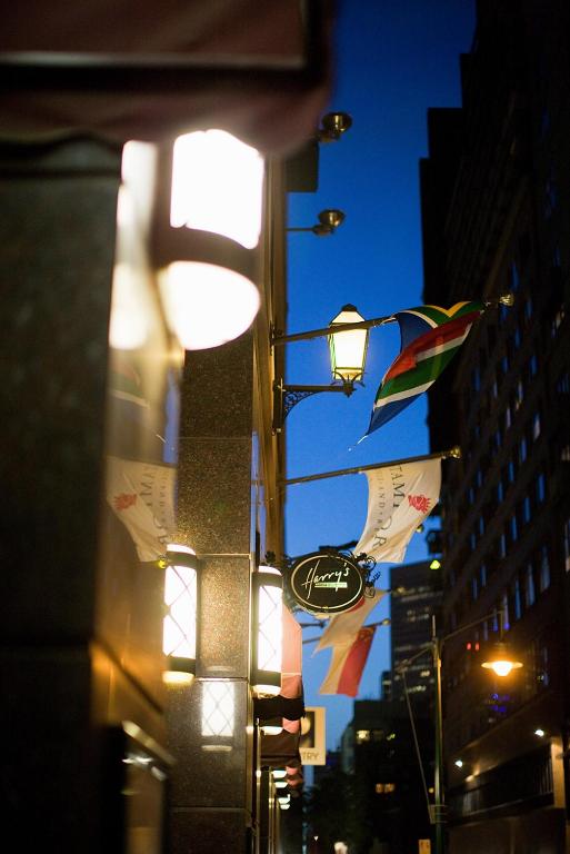 a street light with flags and a sign on a building at Stamford Plaza Melbourne in Melbourne