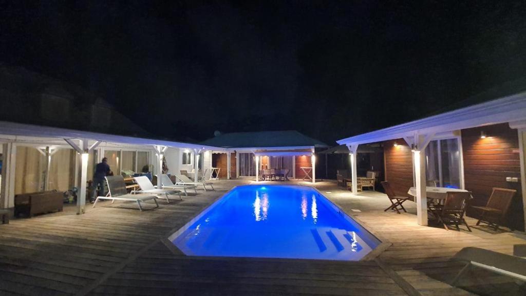 a swimming pool in a yard at night at Location Dampierre in Le Gosier