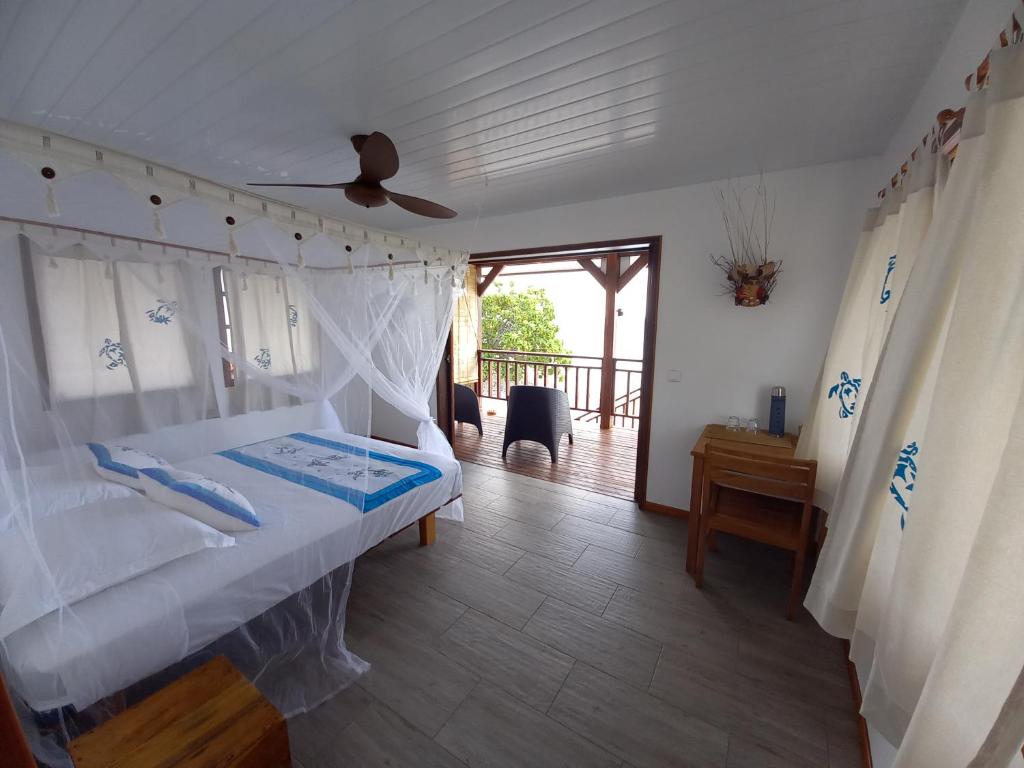 Fafapiti Lodge Fakarava في فاكارافا: غرفة نوم مع سرير ومروحة سقف