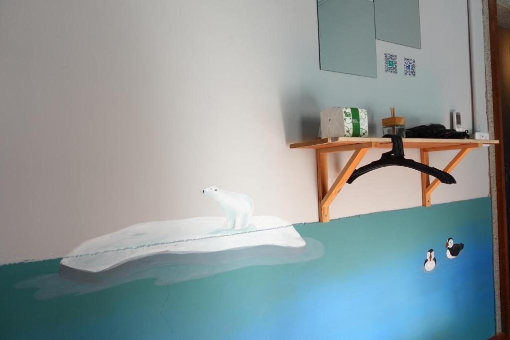 Una cama con un gato blanco sentado encima. en Odyssey Divers Hostel, en Xiaoliuqiu