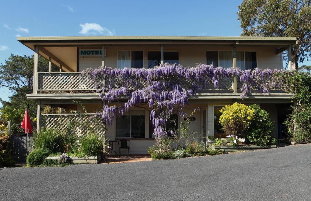 una casa con una corona di fiori viola sopra di Tuross Head Motel a Tuross Heads