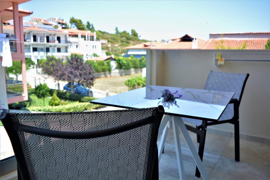 a table and chairs on a balcony with a view at The Archontariki in Ormos Panagias