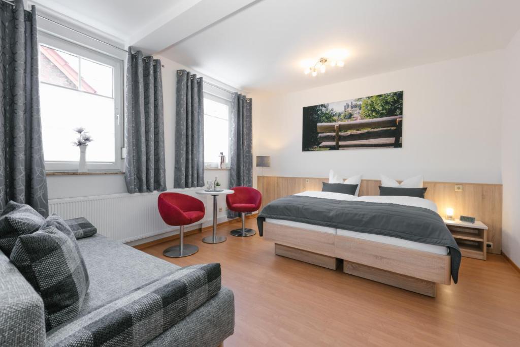 1 dormitorio con 1 cama y 1 sofá en Am Landhof Heiligenstadt Ferienwohnung, en Heilbad Heiligenstadt